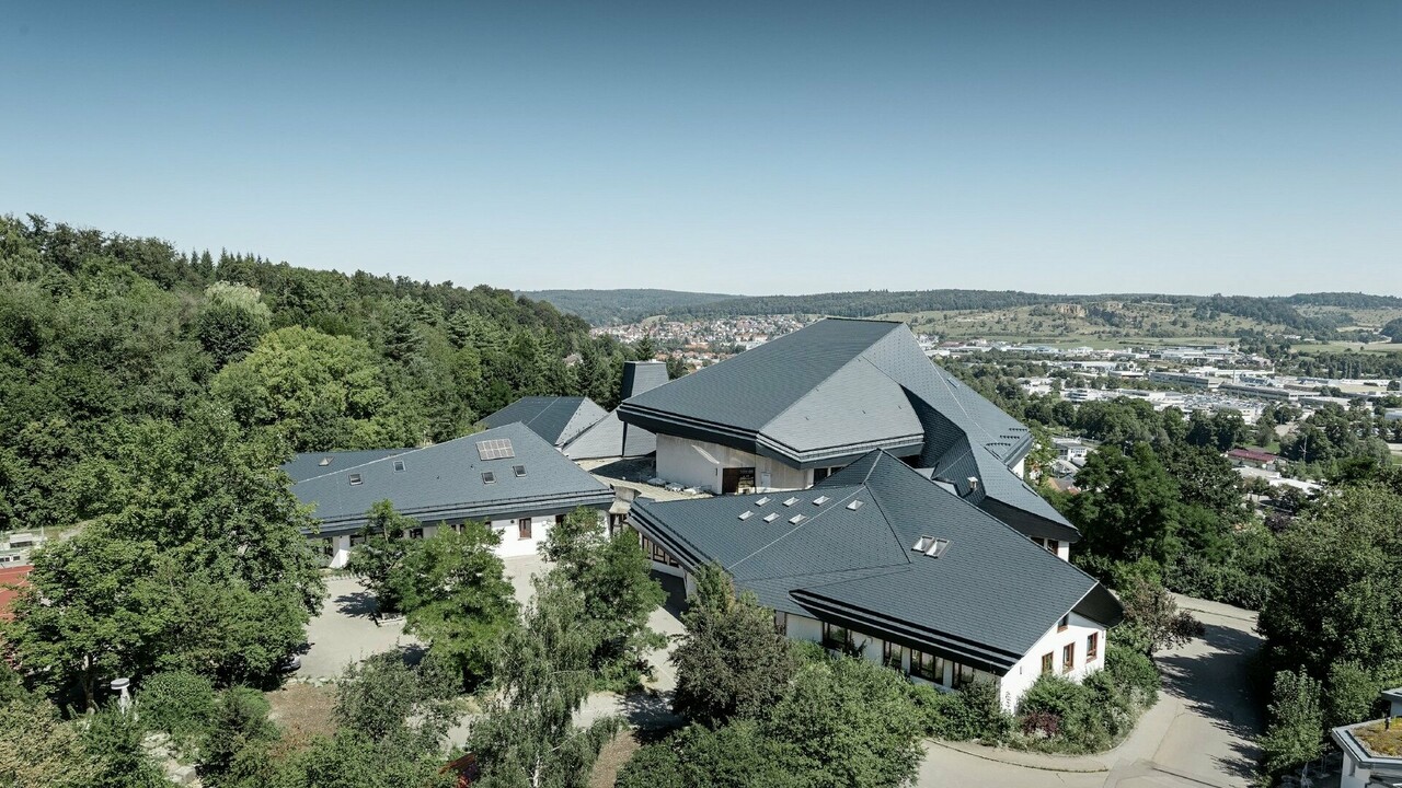 Verwinkelte Dachformen der Waldorfschule Heidenheim eingedeckt mit PREFA Dachschindeln in P.10 Anthrazit