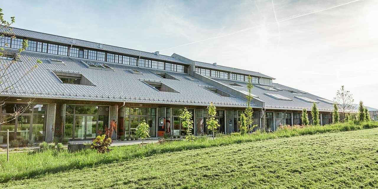 Die neu sanierte Panzerhalle in Salzburg mit vielen Geschäftslokalen und einem neuen PREFA Dach in Silbermetallic