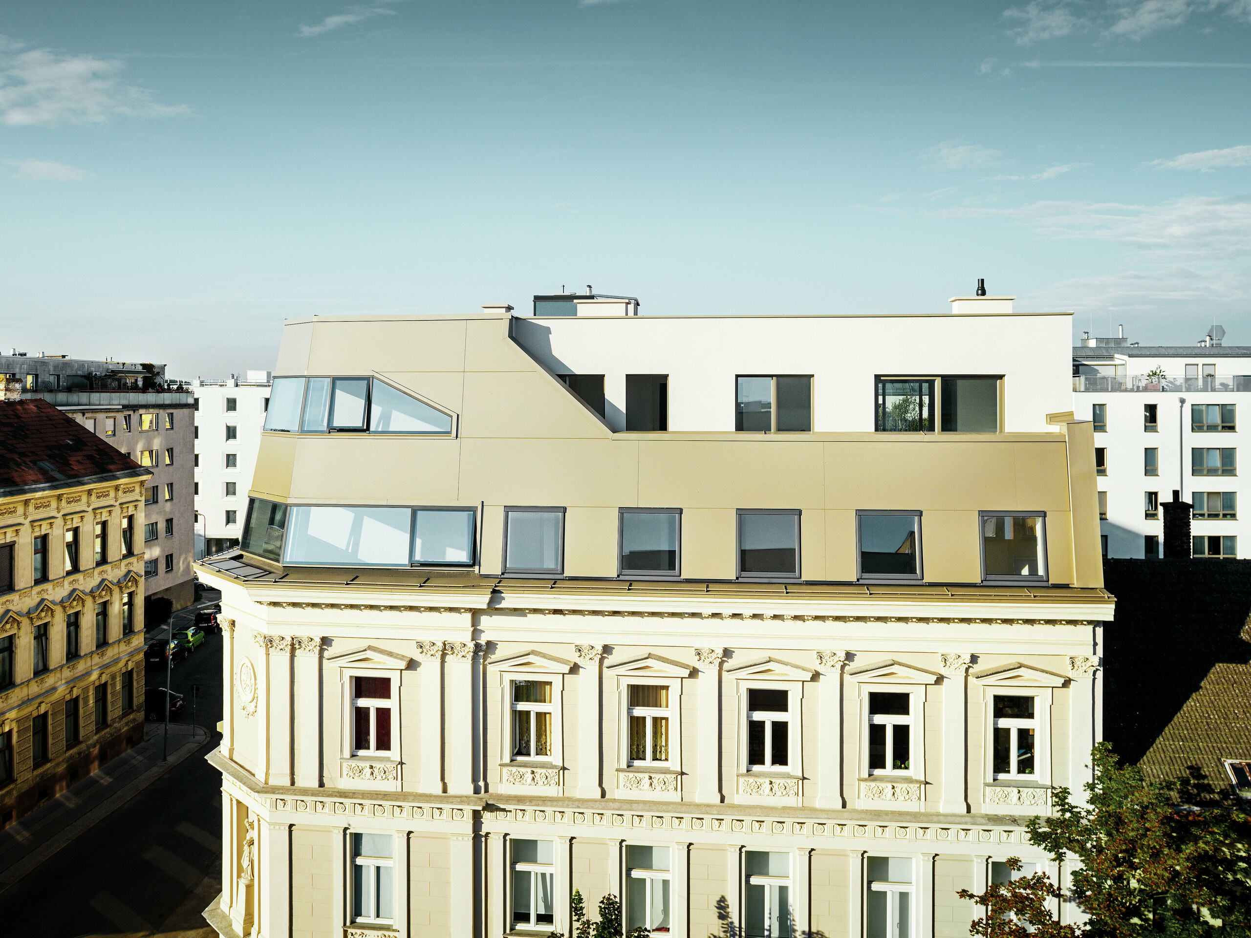 Das neue Dachgeschoss in der Schloßhofer Straße präsentiert sich mit PREFA Aluminium Verbundplatten in Bronze als architektonisch durchdachter Kontrast zum Altbau. Die Kombination aus Funktion, Ästhetik und Langlebigkeit steht für zeitgemäßes städtisches Wohnen. Die klar strukturierten Fensterachsen und die hochwertige Aluminiumfassade schaffen ein durchdachtes Zusammenspiel von Licht, Fläche und Funktionalität.