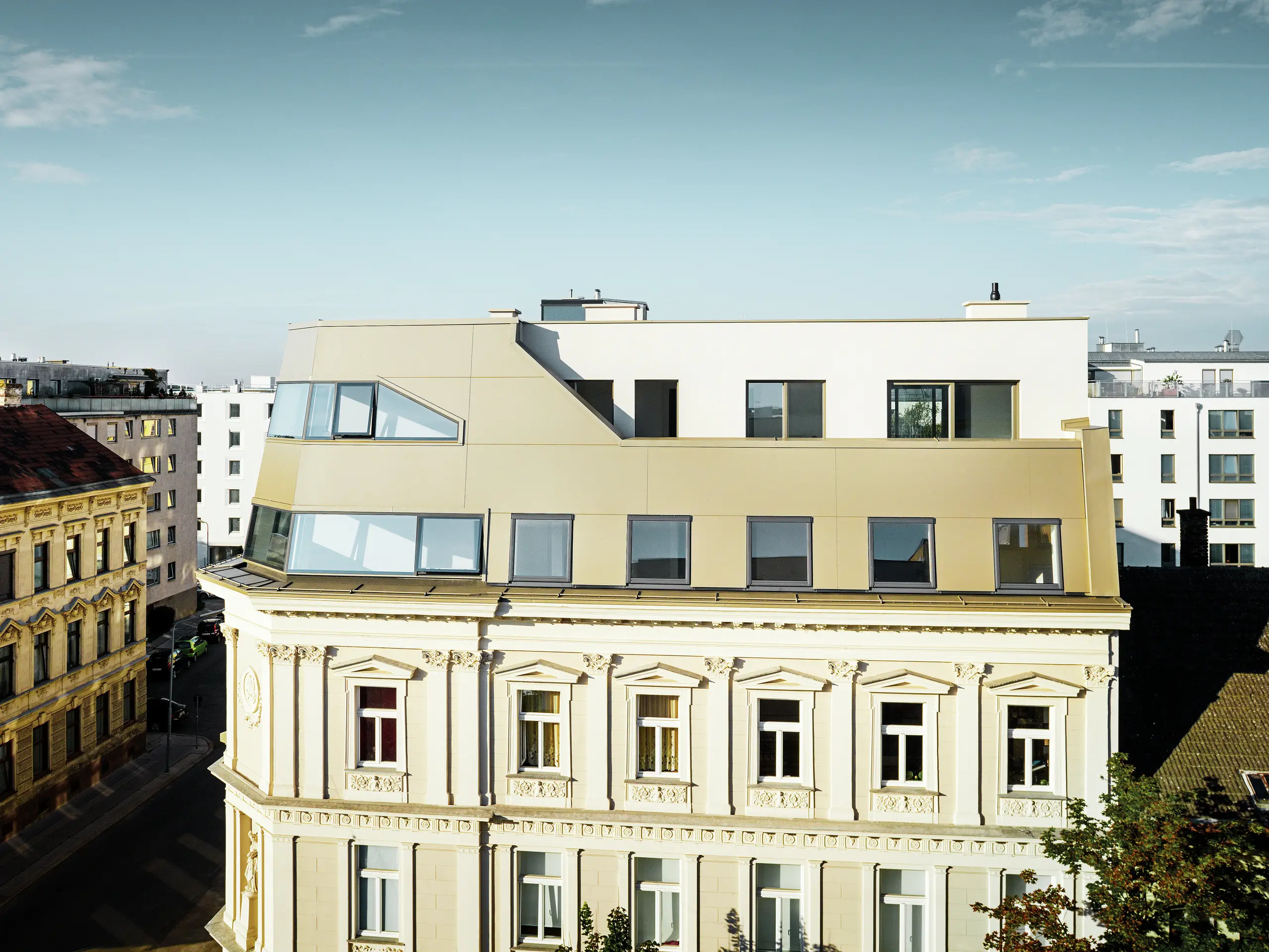Das neue Dachgeschoss in der Schloßhofer Straße präsentiert sich mit PREFA Aluminium Verbundplatten in Bronze als architektonisch durchdachter Kontrast zum Altbau. Die Kombination aus Funktion, Ästhetik und Langlebigkeit steht für zeitgemäßes städtisches Wohnen. Die klar strukturierten Fensterachsen und die hochwertige Aluminiumfassade schaffen ein durchdachtes Zusammenspiel von Licht, Fläche und Funktionalität.
