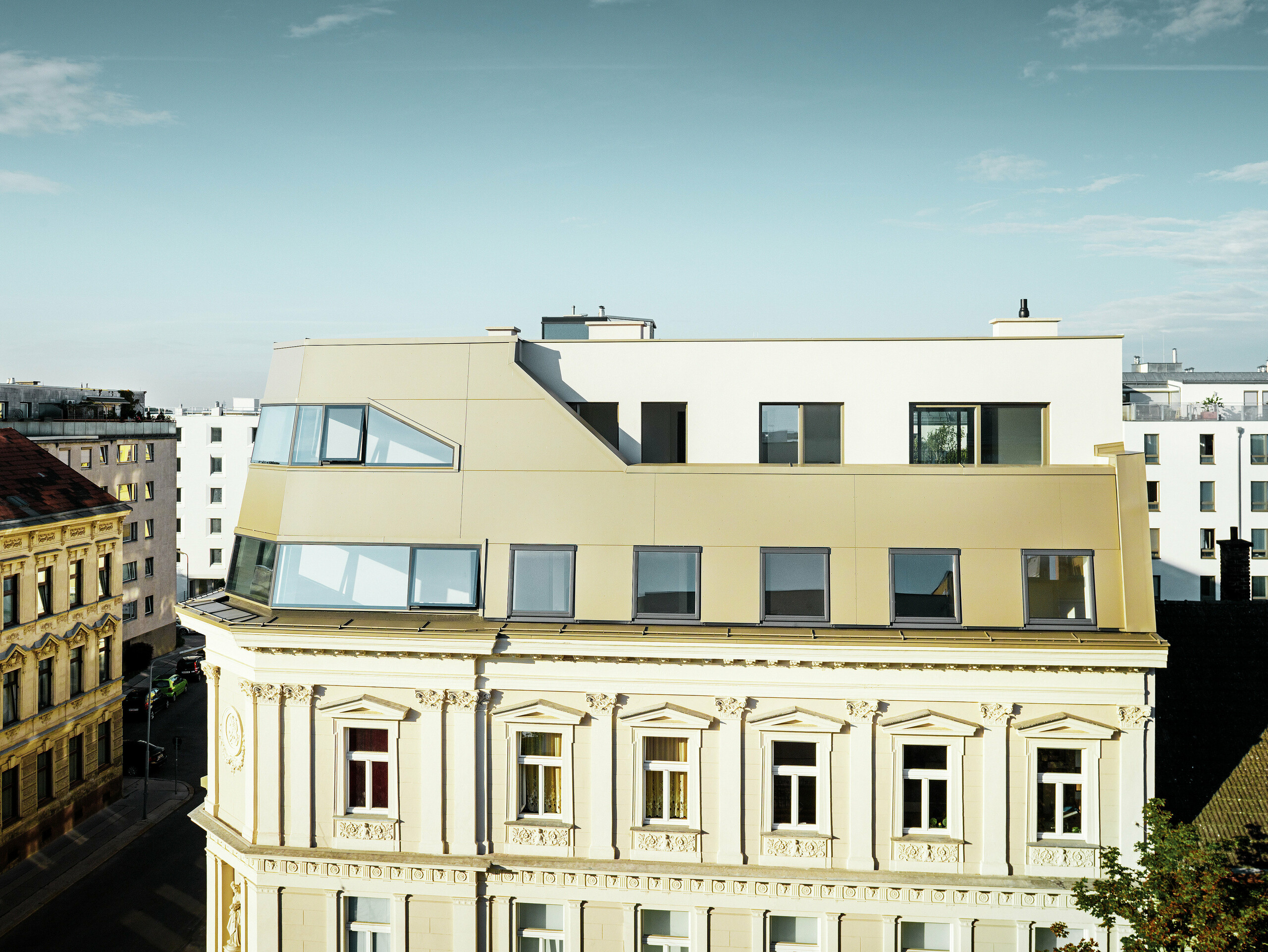 Das neue Dachgeschoss in der Schloßhofer Straße präsentiert sich mit PREFA Aluminium Verbundplatten in Bronze als architektonisch durchdachter Kontrast zum Altbau. Die Kombination aus Funktion, Ästhetik und Langlebigkeit steht für zeitgemäßes städtisches Wohnen. Die klar strukturierten Fensterachsen und die hochwertige Aluminiumfassade schaffen ein durchdachtes Zusammenspiel von Licht, Fläche und Funktionalität.