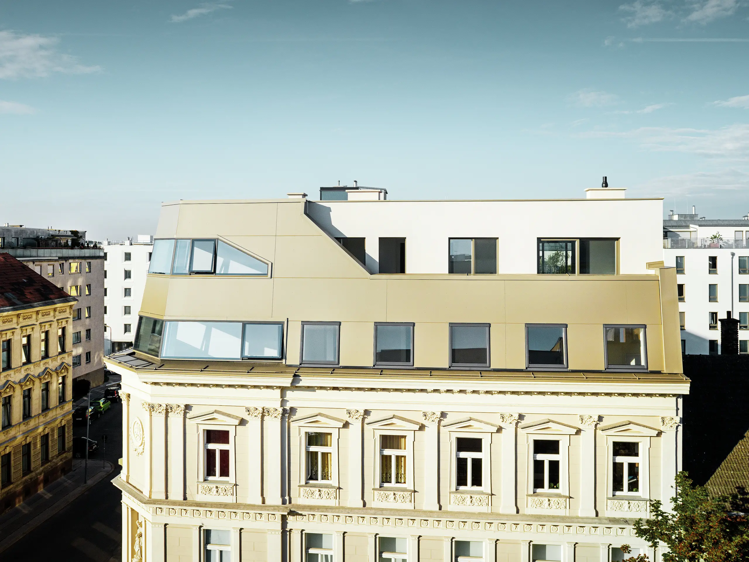 Das neue Dachgeschoss in der Schloßhofer Straße präsentiert sich mit PREFA Aluminium Verbundplatten in Bronze als architektonisch durchdachter Kontrast zum Altbau. Die Kombination aus Funktion, Ästhetik und Langlebigkeit steht für zeitgemäßes städtisches Wohnen. Die klar strukturierten Fensterachsen und die hochwertige Aluminiumfassade schaffen ein durchdachtes Zusammenspiel von Licht, Fläche und Funktionalität.