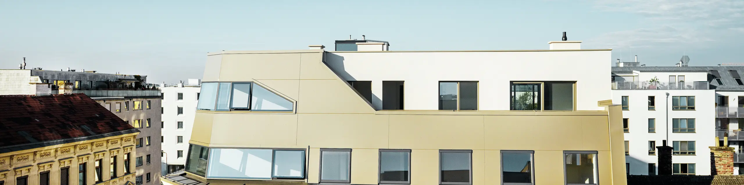 Das neue Dachgeschoss in der Schloßhofer Straße präsentiert sich mit PREFA Aluminium Verbundplatten in Bronze als architektonisch durchdachter Kontrast zum Altbau. Die Kombination aus Funktion, Ästhetik und Langlebigkeit steht für zeitgemäßes städtisches Wohnen. Die klar strukturierten Fensterachsen und die hochwertige Aluminiumfassade schaffen ein durchdachtes Zusammenspiel von Licht, Fläche und Funktionalität.