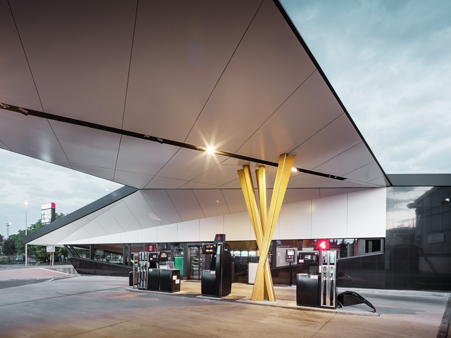 Eine weitere seitliche Ansicht der Tankstelle mit der Unterseite des Dachs und den Stützengruppen im Blick.