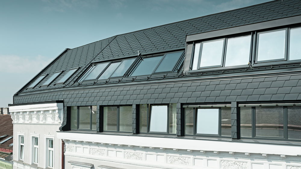 Dachgeschossausbau einer Wohnhausanlage in Wien mit der Dachschindel in P.10 Anthrazit